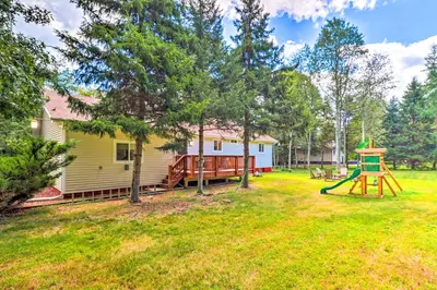 a yard with a playground and a house at Walk to Wolf Run Lake Cottage with Furnished Deck in Albrightsville