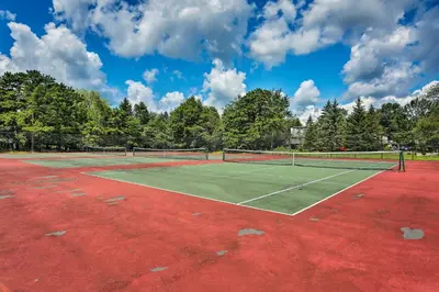 a tennis court with two tennis rackets on it at Walk to Wolf Run Lake Cottage with Furnished Deck in Albrightsville