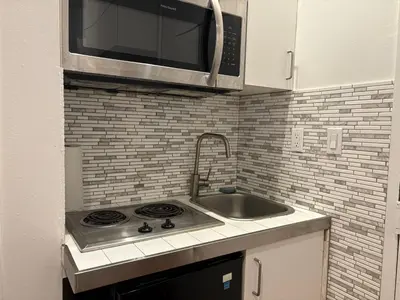 a kitchen with a sink and a microwave at The Cityline Residences in New York