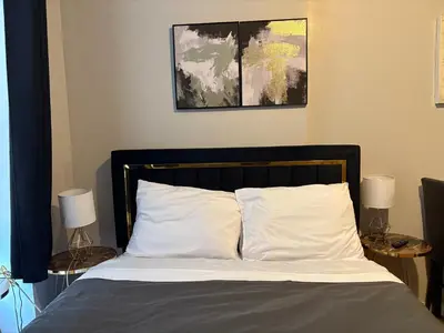 a bed with white pillows and two lamps on tables at The Cityline Residences in New York