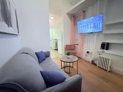 a living room with a couch and a flat screen tv at The Cityline Residences in New York