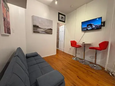 a living room with a couch and a table and a tv at The Cityline Residences in New York