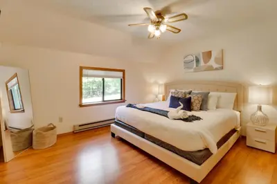 a bedroom with a bed and a ceiling fan at Poconos Cabin Serene Deck, Fire Pit and Game Room in Tobyhanna