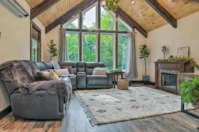 a living room with a couch and a fireplace at Pet-Friendly Delta Cabin with Private Hot Tub! in Delta
