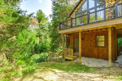 a cabin in the woods with a porch and a deck at Pet-Friendly Delta Cabin with Private Hot Tub! in Delta