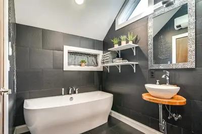 a bathroom with a white tub and a sink at Pet-Friendly Delta Cabin with Private Hot Tub! in Delta