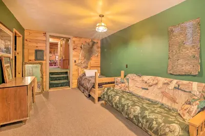 a living room with a couch and a bed at Handcrafted Log Cabin in Candor Group Getaway! in Candor