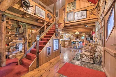 a spiral staircase in a room with wooden walls at Handcrafted Log Cabin in Candor Group Getaway! in Candor