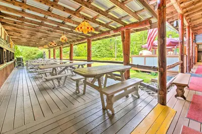 a wooden deck with picnic tables and benches on it at Handcrafted Log Cabin in Candor Group Getaway! in Candor