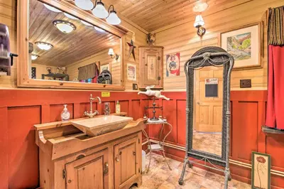 a bathroom with a sink and a mirror at Handcrafted Log Cabin in Candor Group Getaway! in Candor