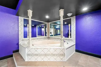 a bathroom with a tub and purple walls at Red Carpet Inn and Suites in Bellmawr