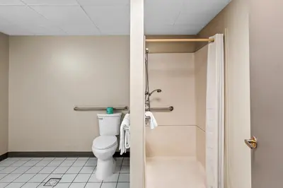 a bathroom with a toilet and a shower at Red Carpet Inn and Suites in Bellmawr