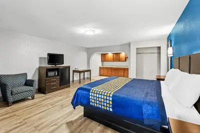 a hotel room with a bed and a tv at Red Carpet Inn and Suites in Bellmawr
