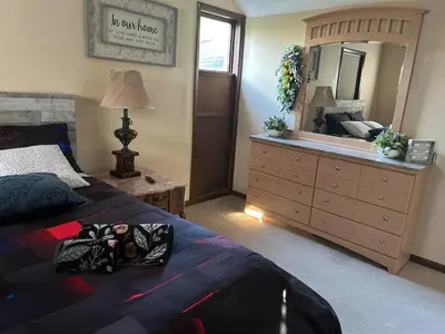 a bedroom with a bed and a dresser with a mirror at WOW!! Ultimate Pocono Retreat, Hot Tub, Game Room, Deck, Lakes, Skiing, Pools in Long Pond