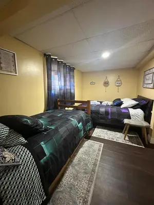 a bedroom with two beds and a couch and a rug at WOW!! Ultimate Pocono Retreat, Hot Tub, Game Room, Deck, Lakes, Skiing, Pools in Long Pond