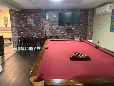 a room with a pool table and a tv at WOW!! Ultimate Pocono Retreat, Hot Tub, Game Room, Deck, Lakes, Skiing, Pools in Long Pond