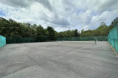 a tennis court with a net on it at WOW!! Ultimate Pocono Retreat, Hot Tub, Game Room, Deck, Lakes, Skiing, Pools in Long Pond