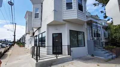 a white building with a black gate on a street at Great Studio Apartment by Universities in Philadelphia
