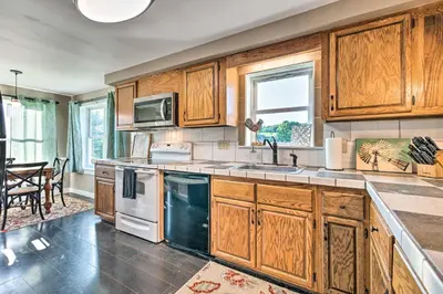 a kitchen with wooden cabinets and a counter top at Deck and Game Room Home in Pennsylvania Countryside in Klingerstown