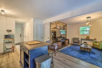 a kitchen and living room with a blue rug at Chic Tobyhanna Home with Furnished Deck Space! in Tobyhanna