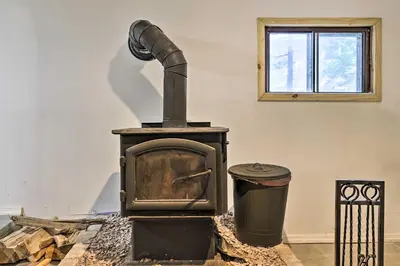 an old wood stove and a trash can in a room at Chic Tobyhanna Home with Furnished Deck Space! in Tobyhanna