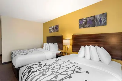 two beds in a hotel room with yellow walls at Sleep Inn North - Central York in York