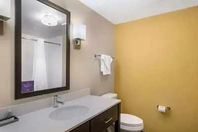 a bathroom with a sink and a toilet and a mirror at Sleep Inn North - Central York in York
