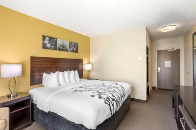 a hotel room with a large bed and a flat screen tv at Sleep Inn North - Central York in York
