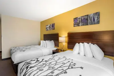 two beds in a hotel room with yellow walls at Sleep Inn North - Central York in York