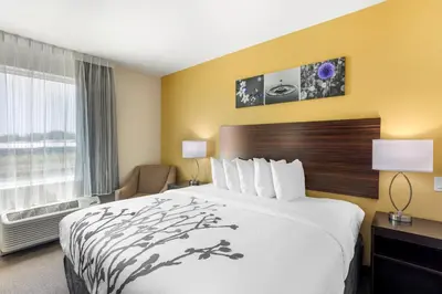 a hotel room with a large bed and a window at Sleep Inn North - Central York in York