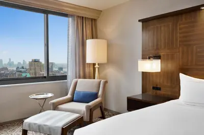 a hotel room with a bed and a chair and a window at Hilton New York Times Square in New York