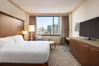 a hotel room with a large bed and a large window at Hilton New York Times Square in New York