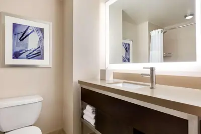 a bathroom with a sink and a toilet and a mirror at Hilton New York Times Square in New York