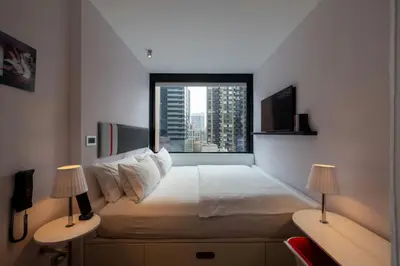 a bedroom with a large bed with a large window at citizenM New York Times Square in New York