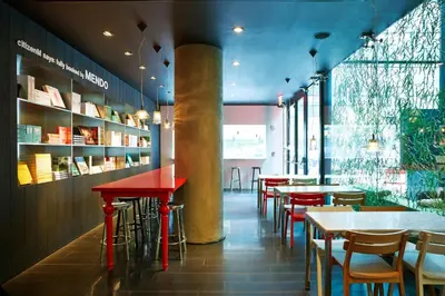 a restaurant with red tables and chairs and windows at citizenM New York Times Square in New York