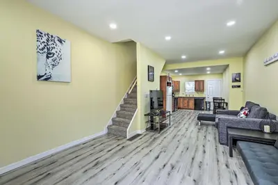 a living room with a couch and a staircase at Philly Townhome with Gas Grill about 5 Mi to Dtwn! in Philadelphia
