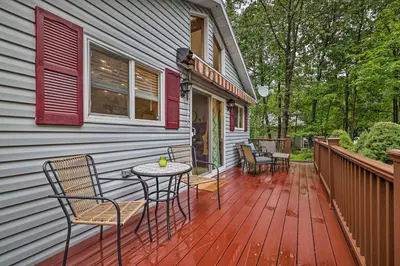 a deck with chairs and a table on a house at Charming Albrightsville Home with Gas Fire Pit! in Albrightsville