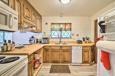 a kitchen with wooden cabinets and white appliances at Walk to Lake Game Room Getaway in Pocono Summit! in Pocono Summit
