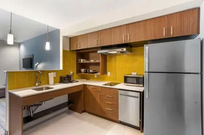 a kitchen with wooden cabinets and a stainless steel refrigerator at MainStay Suites North - Central York in York