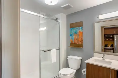 a bathroom with a shower and a toilet and a sink at MainStay Suites North - Central York in York