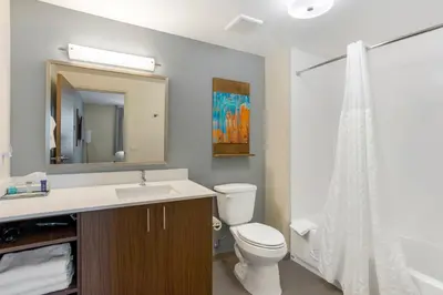 a bathroom with a sink and a toilet and a mirror at MainStay Suites North - Central York in York