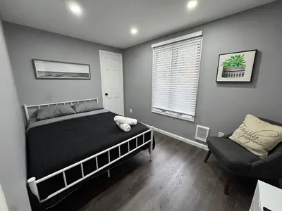 a bedroom with a bed and a chair and a window at Casa Rosado @ Pocono II by Lake Hot Tub Camelback in Tobyhanna