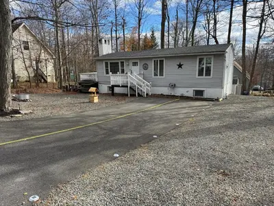 a white house with a porch and a driveway at Casa Rosado @ Pocono II by Lake Hot Tub Camelback in Tobyhanna