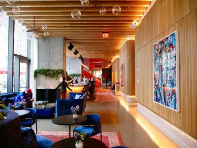 a lobby with tables and chairs and people in a building at Virgin Hotels New York City in New York