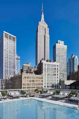 a large swimming pool with a city skyline in the background at Virgin Hotels New York City in New York