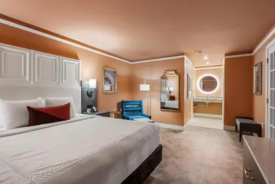 a hotel room with a bed and a blue chair at The Inn at Lewisburg, BW Signature Collection in Lewisburg