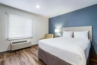 a bedroom with a large bed and a window at WoodSpring Suites Harrisburg Linglestown in Harrisburg
