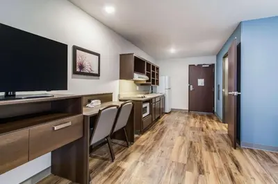 a kitchen with a desk and a television in a room at WoodSpring Suites Harrisburg Linglestown in Harrisburg