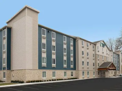 an apartment building with a blue and white building at WoodSpring Suites Harrisburg Linglestown in Harrisburg