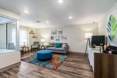 a living room with a couch and a tv at WoodSpring Suites Harrisburg Linglestown in Harrisburg